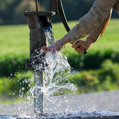 Person pumping a water well. 
