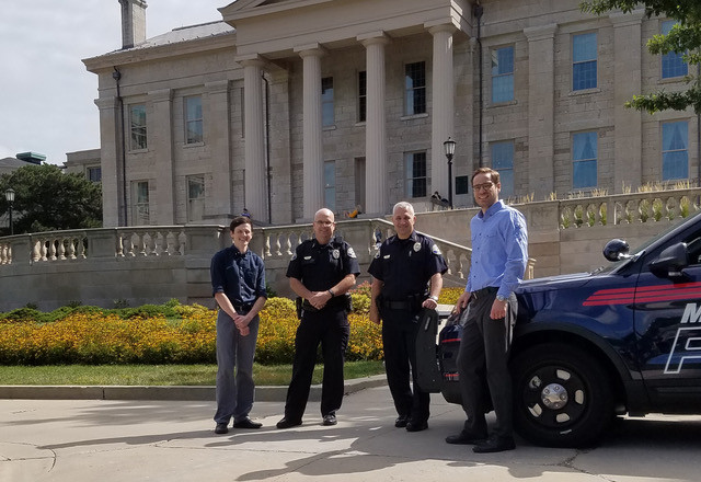 Mark Berg and Ethan Rogers stand in front of the Old Capitol with Marion Police