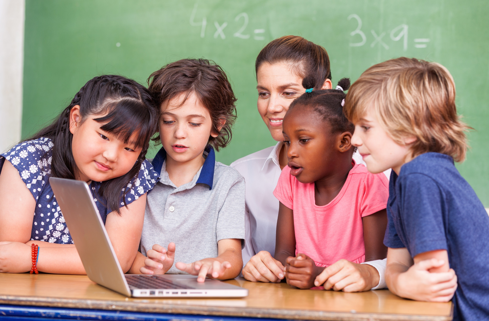 Young students huddled around a laptop