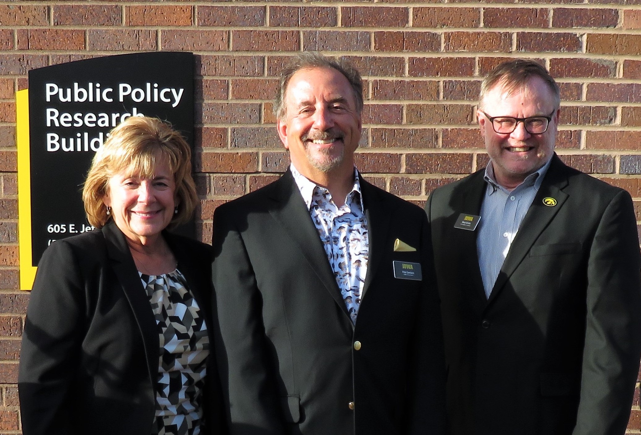 University President Barbara Wilson, Public Policy Center Director Peter Damiano, and Vice President for Research Marty Scholtz stand in front of the newly opened Public Policy Research Building