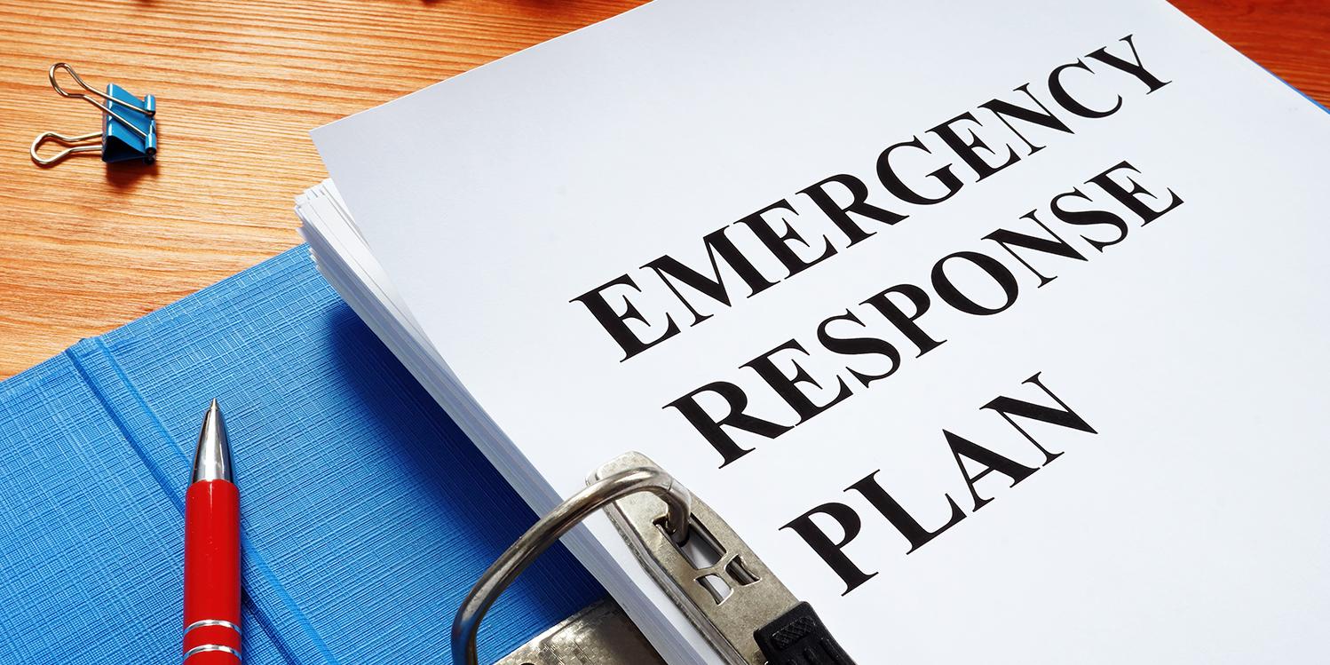 Binder on a desk, open to a title page that says Emergency Response Plan