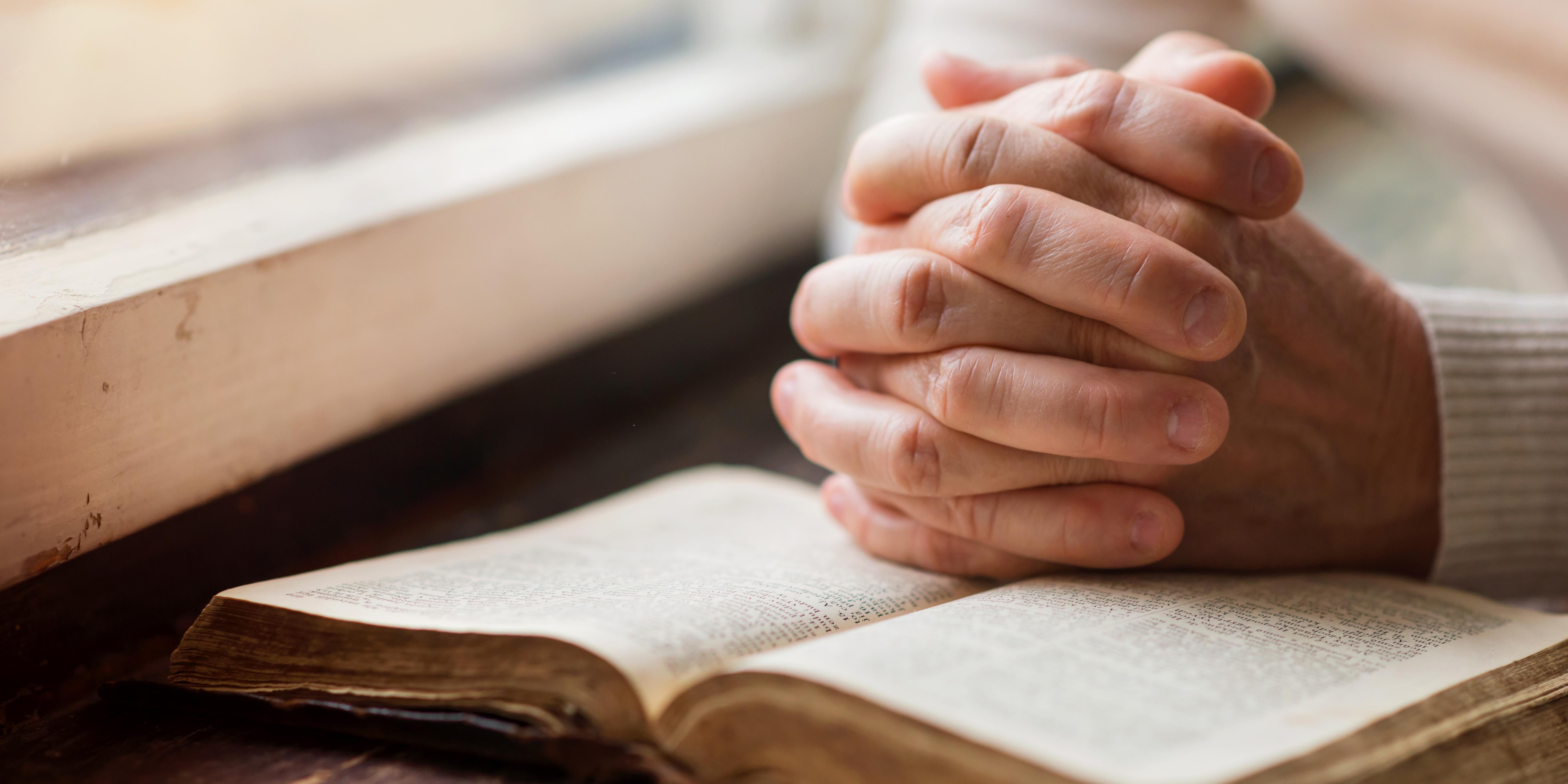prayer hands with a religious text