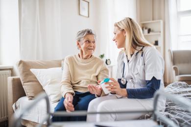 Elderly patient sitting on couch with nurse