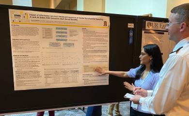 Ingleshwar explaining her poster to a conference attendee