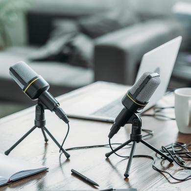 Two podcast microphones and laptop. 